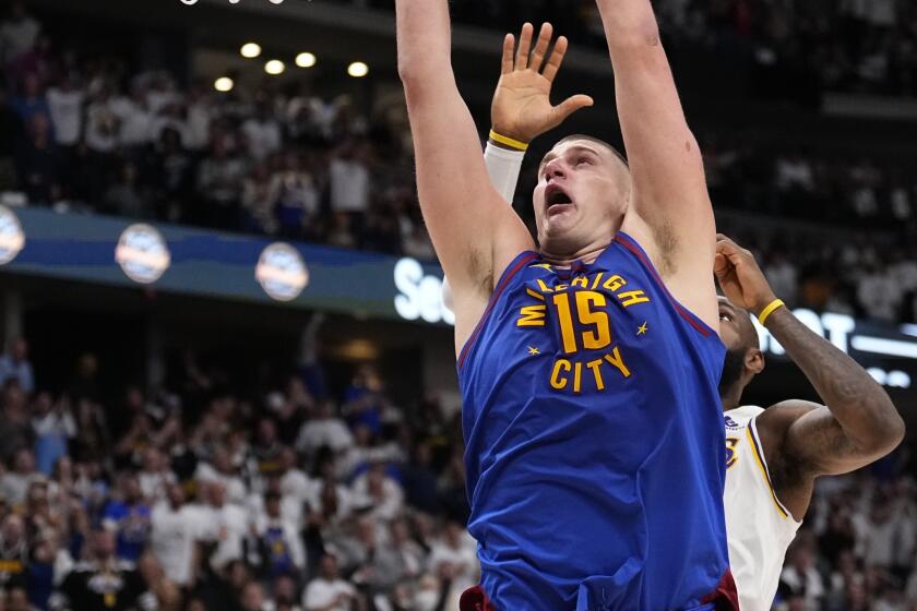 El serbio Nikola Jokic, de los Nuggets de Denver, realiza una clavada frente a LeBron James, de los Lakers de Los Ángeles, el sábado 20 de abril de 2024 (AP Foto/Jack Dempsey)