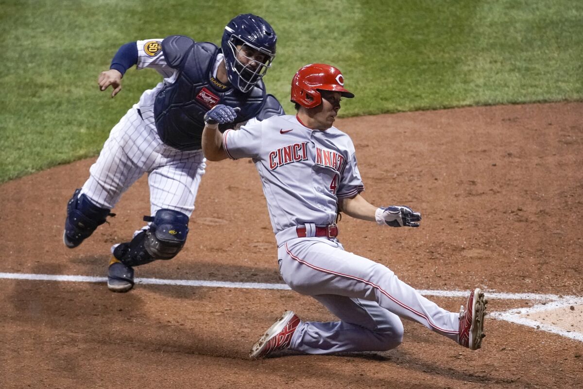 Milwaukee Brewers catcher Omar Narvaez tags out Cincinnati Reds' Shogo Akiyama at home during the seventh inning of a baseball game Saturday, Aug. 8, 2020, in Milwaukee. Akiyama tried to score from third on a ball hit by Joey Votto. (AP Photo/Morry Gash)