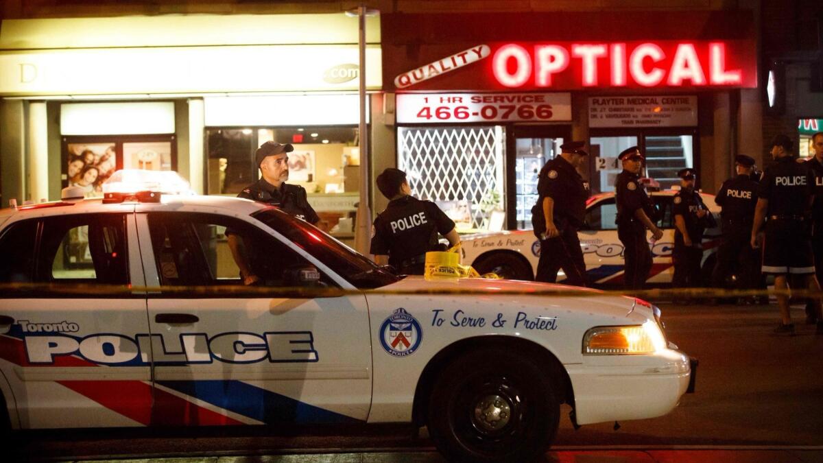 Toronto police officers work at the scene of a mass shooting on July 23.