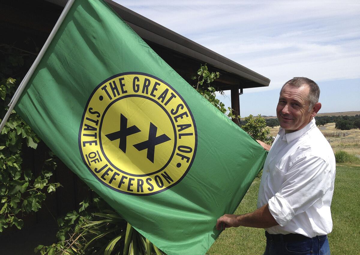 Tom Knorr, chairman of the Measure A campaign in Tehama County, holds a State of Jefferson flag at his ranch house in Corning, Calif.