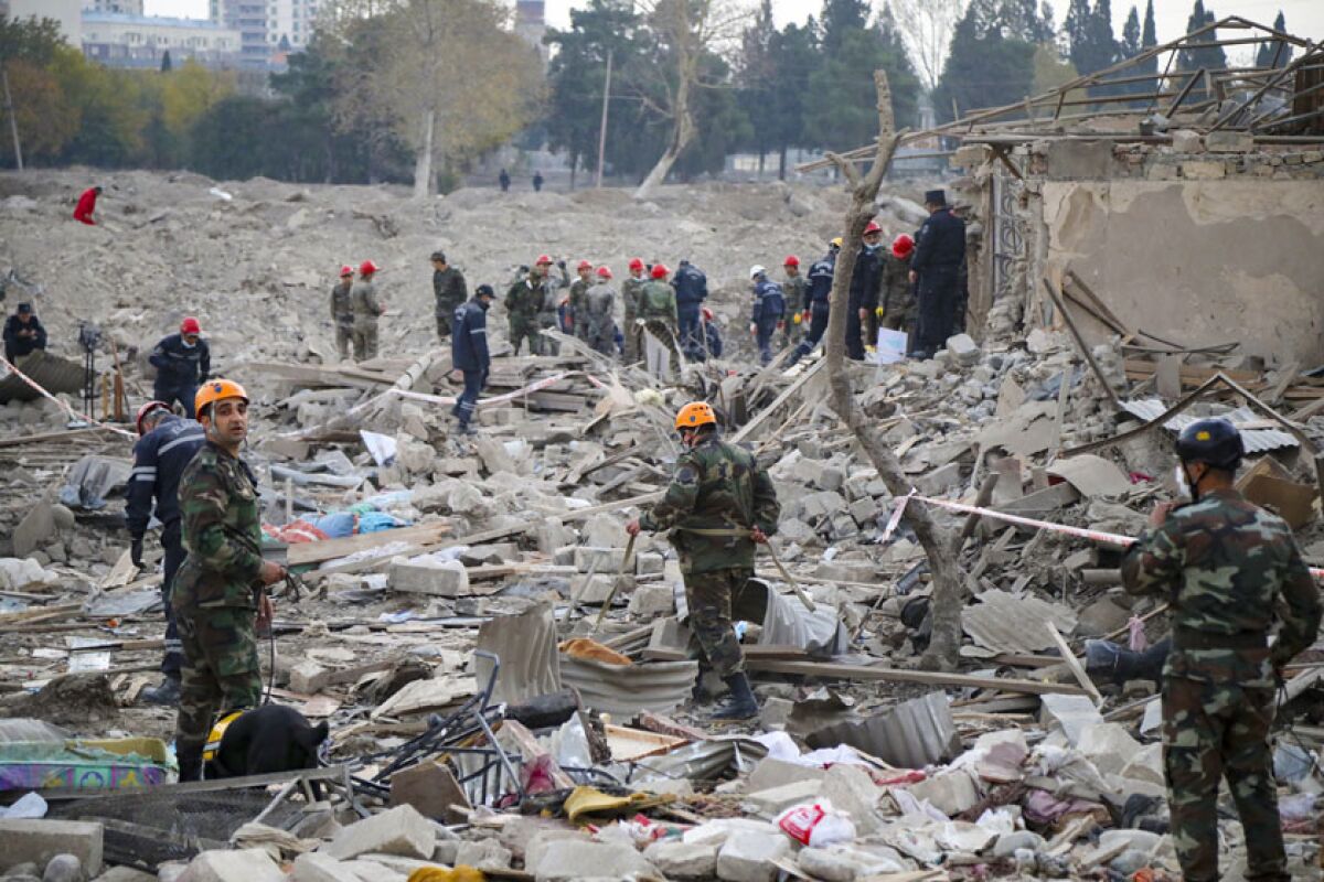 Rescuers search for survivors in a residential area in Gyanga, Azerbaijan, that was hit by rocket fire.