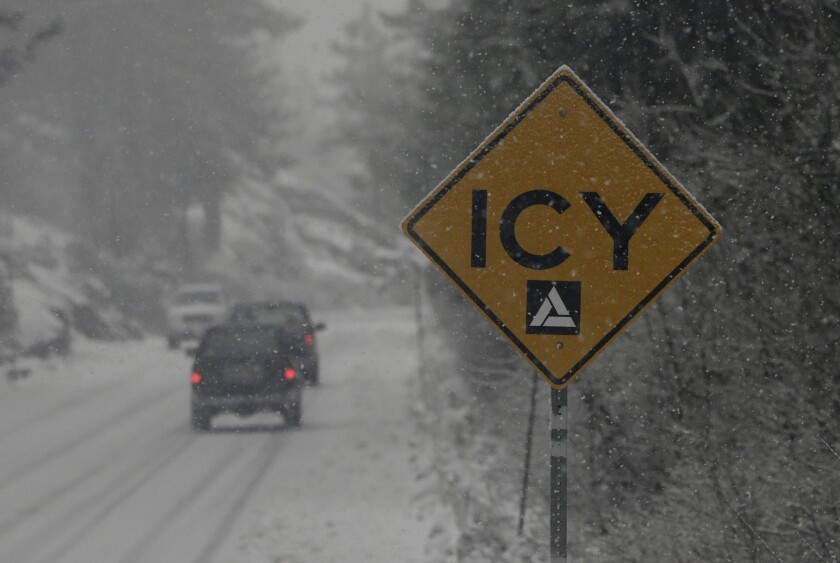 A sign warns drivers of the road conditions on Donner Pass Road near Soda Springs, Calif., on Thursday. Several inches of snow from a severe storm that swept through Northern California fell in the Sierra Nevada.