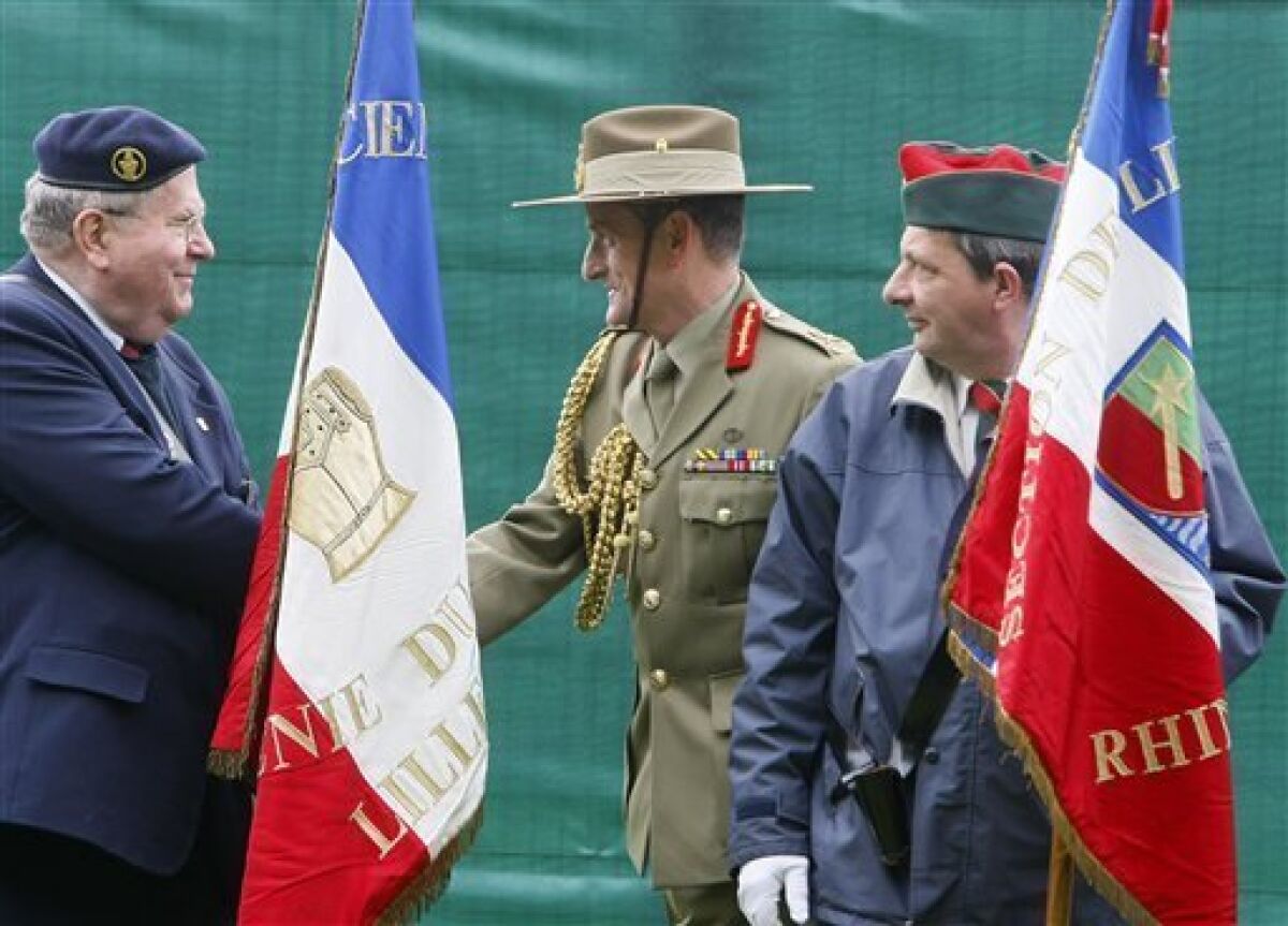Australian Army officer Major General Mike O'Brien, head of the Australian Fromelles Project Group, center, shakes hand with a French veteran in Fomelles, northern France, during a ceremony Tuesday, May 5, 2009. Archaeologists have begun excavating a cluster of mass graves in northern France that contain remains of as many as 400 Australian and British soldiers who perished at the WW I battle of Fromelles in July 1916.(AP Photo/Michel Spingler)