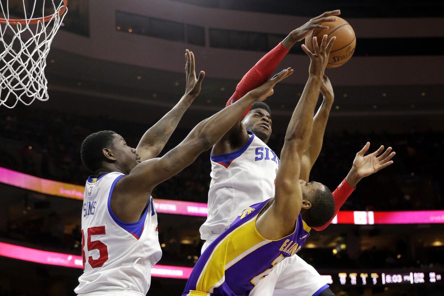 Lakers shooting guard Wayne Ellington gets his shot rejected by 76ers center Nerlens Noel, middle, while center Henry Sims, 35, is also there to try to block the shot.