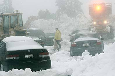 STUCK: Caltrans crews work to clear a section of California Highway 18, where dozens of vehicles were stranded by the heavy snowfall.