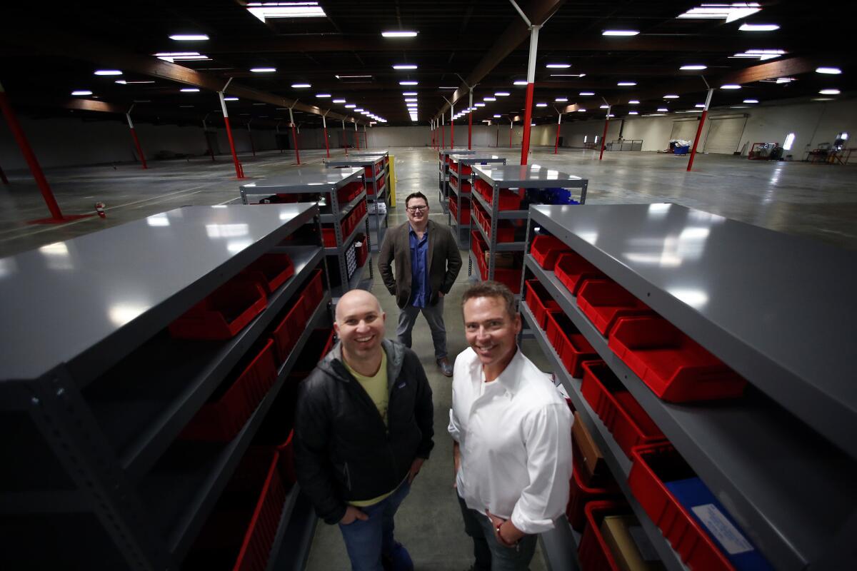 Porter Harris and Michael Patterson left to right in the foreground, with Erik Fleming, in Romeo Power's Vernon battery pack factory.