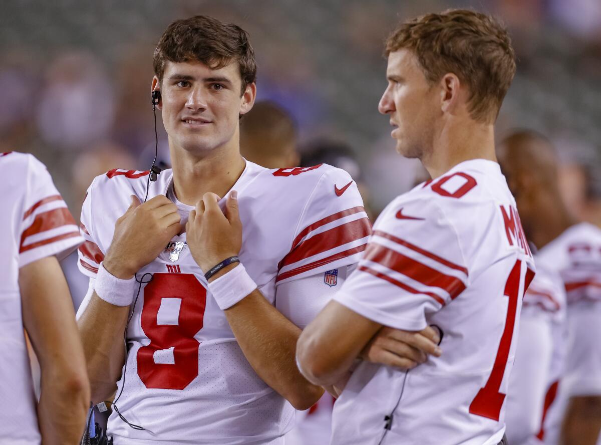 New Giants starting quarterback Daniel Jones, left, talks with the former starter, Eli Manning.