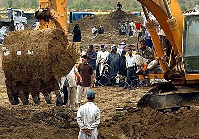 A bulldozer unearths a mass grave near Hilla, Iraq, of people believed to have been executed by Baath party members following the Gulf War. The bulldozer was donated by a family who lost four of its relatives.