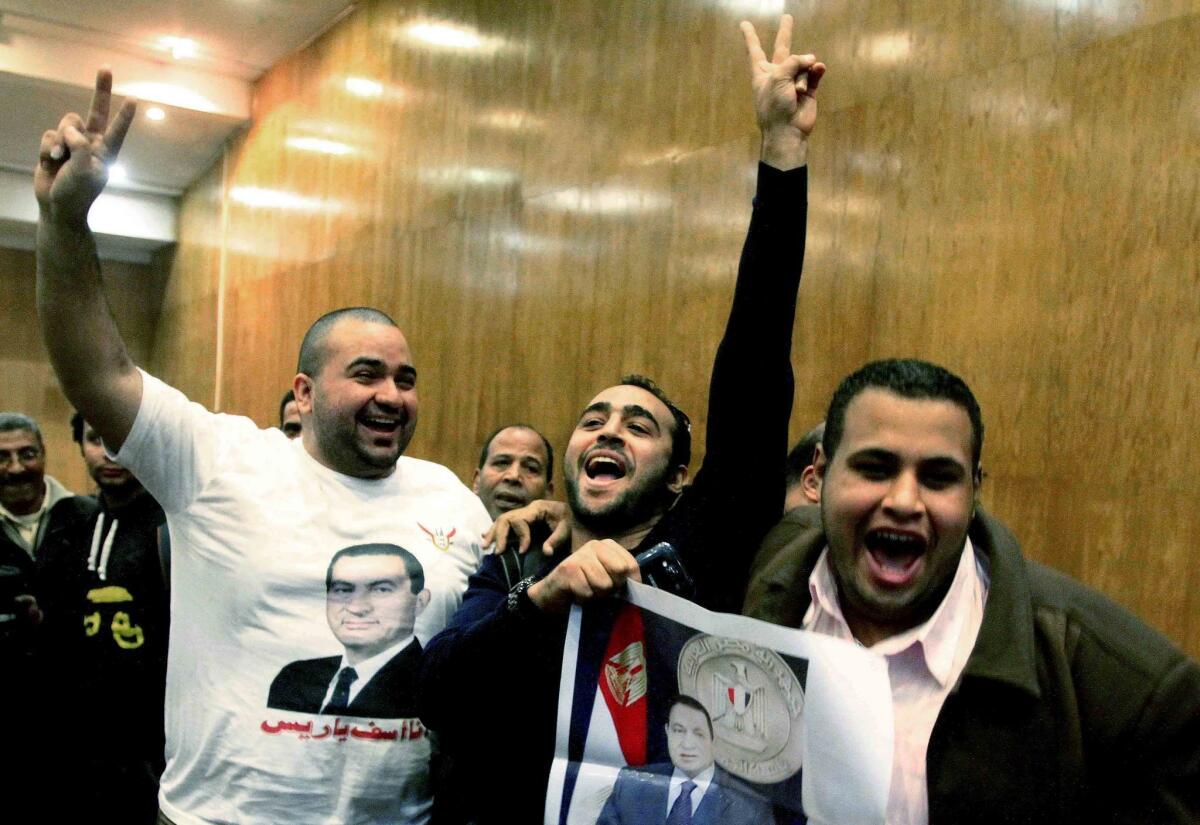Egyptian supporters of former leader Hosni Mubarak celebrate in Cairo on Thursday after a court acquitted Mubarak's two sons and his last prime minister of corruption charges.