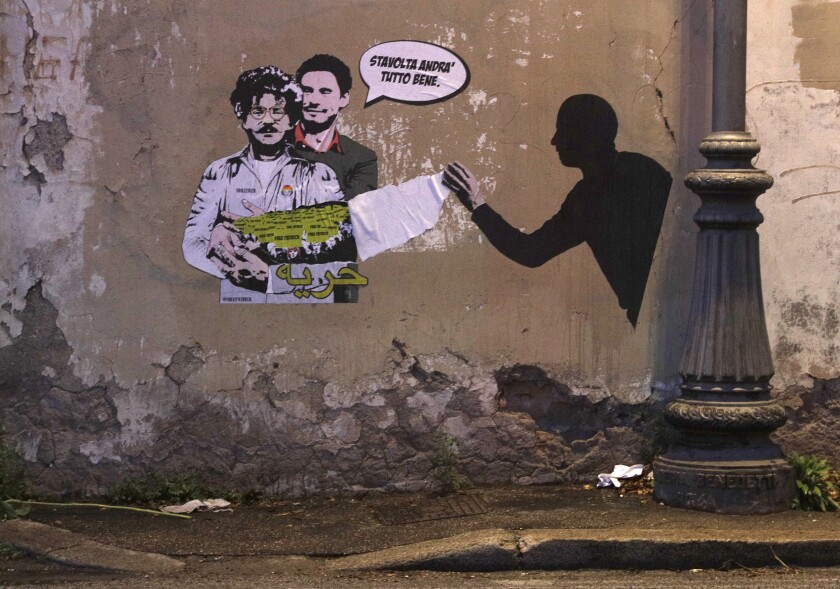FILE - A mural depicts detained Egyptian human rights advocate and student at the University of Bologna in Italy, Patrick George Zaki, being hugged from behind by Italian researcher Giulio Regeni, who was murdered in Cairo in 2016, on a wall in Rome, Feb. 19, 2020. A rights group said Tuesday, Dec. 7, 2021 that an Egyptian court has ordered the release pending trial of Zaki, an activist who has been imprisoned for nearly two years. The court in the Nile Delta town of Mansoura postponed his trial until Feb. 1. Writing in Italian at top reads: "This time it will all go well", and in Arabic at the bottom reads "freedom." (AP Photo/Gregorio Borgia, File)