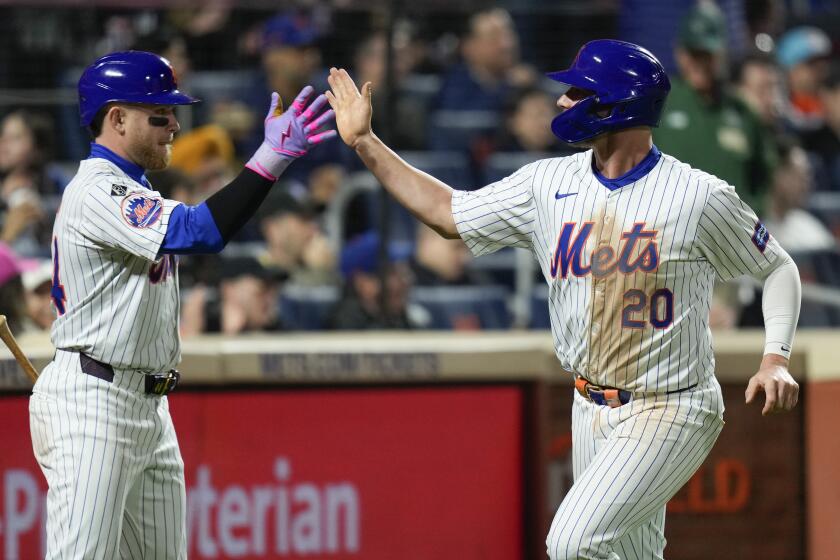 New York Mets' Pete Alonso, right, is greeted by Harrison Bader after Alonso scored on a balk by Pittsburgh Pirates pitcher Jose Hernandez during the seventh inning of a baseball game Tuesday, April 16, 2024, in New York. (AP Photo/Seth Wenig)