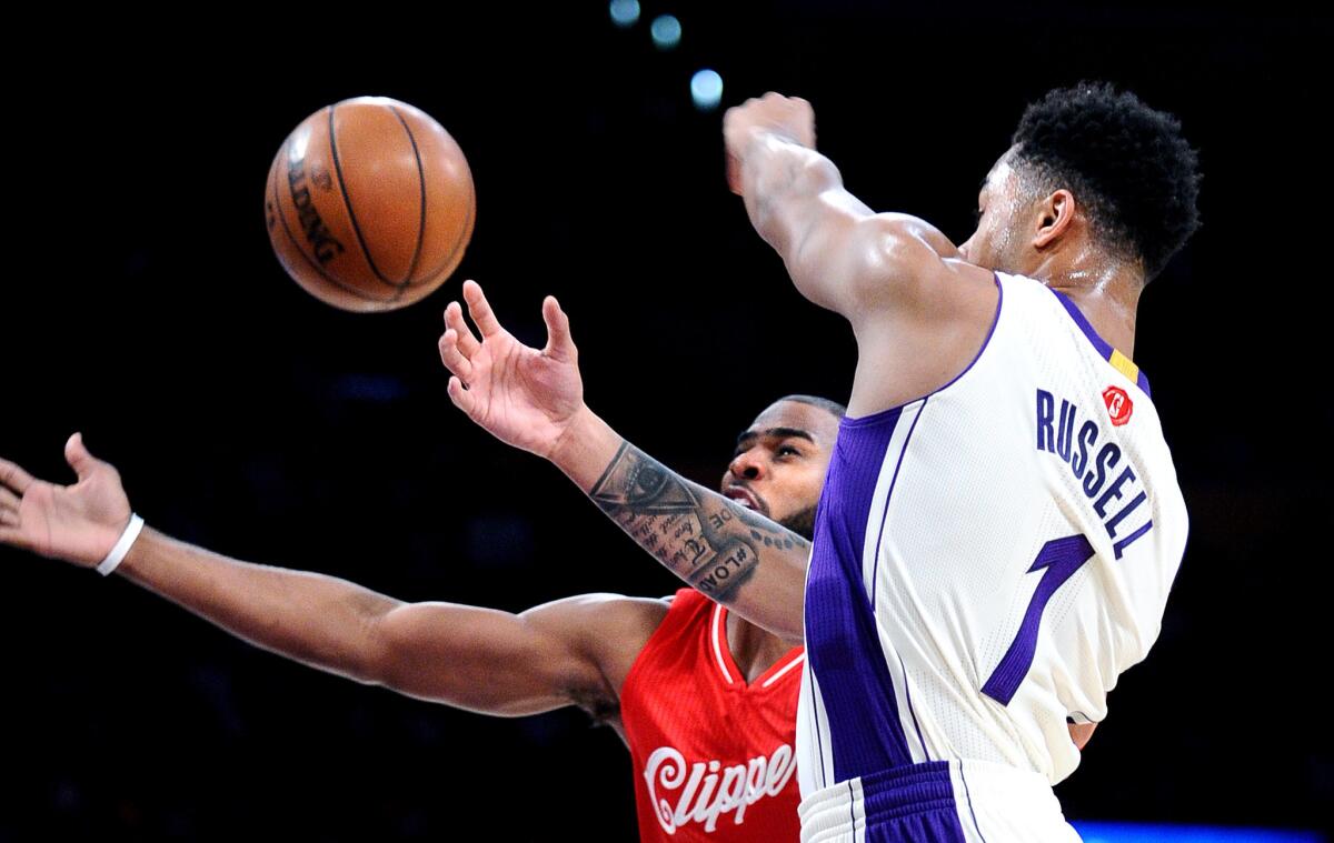 Guards Chris Paul of the Clippers and D'Angelo Russell of the Lakers try to track down a loose ball.