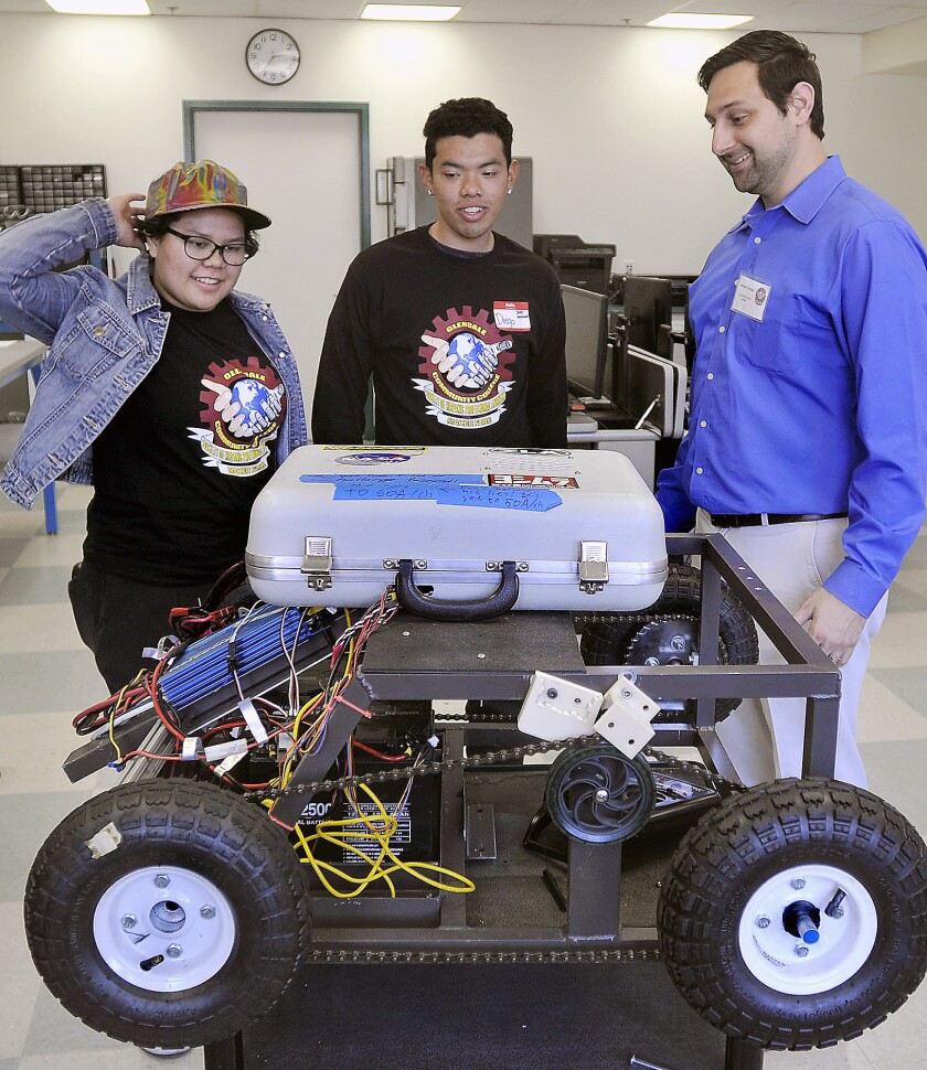Glendale Community College engineering students Delmi Martinez, left, and Diego Barreto get a tour of the robotics lab with Armen Toorian, GCC engineering clinic director, as part of the the Society of Hispanic Professional Engineers Maker Faire held at the campus student center, Saturday, Feb. 27, 2016.