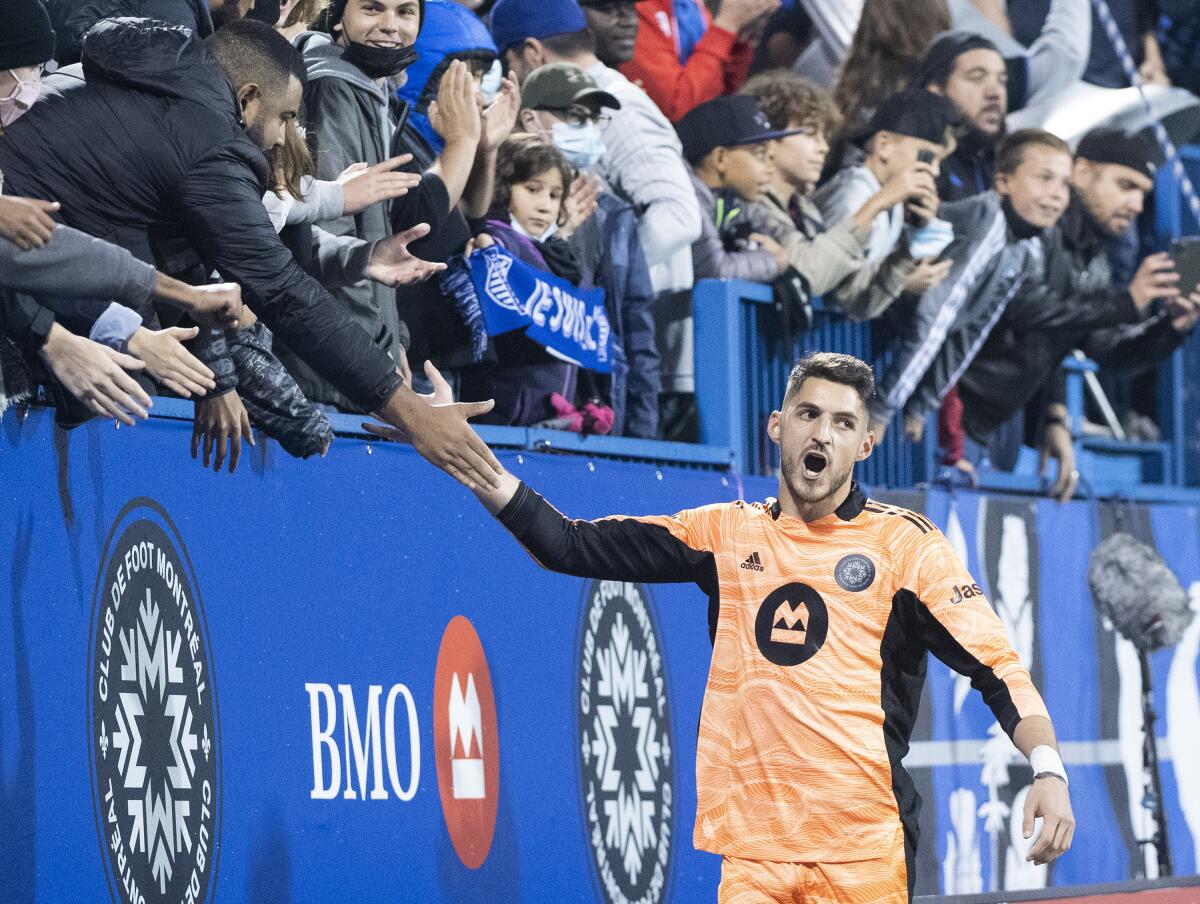 CF Montreal goalkeeper Jame Pantemis celebrates with fans after defeating Atlanta United in an MLS soccer game in Montreal, Saturday, Oct. 2, 2021. (Graham Hughes/The Canadian Press via AP)
