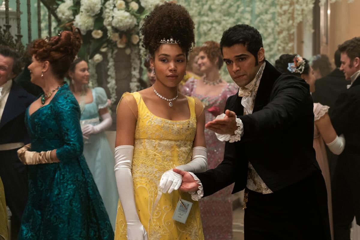 A man and a woman in Regency garb in a ballroom setting in "Bridgerton."