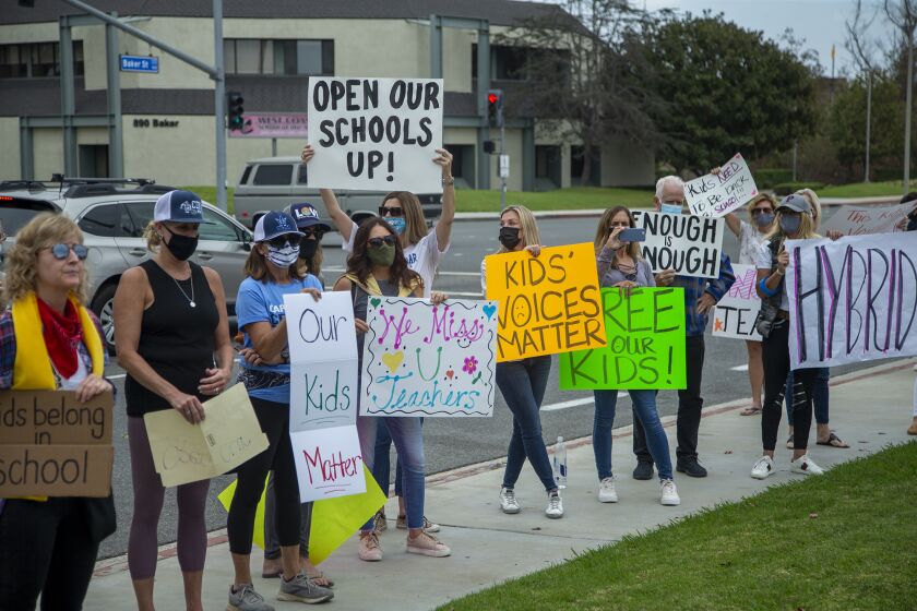 A mixture of students and parents protest outside the Newport-Mesa Unified School District office on Friday, October 23.