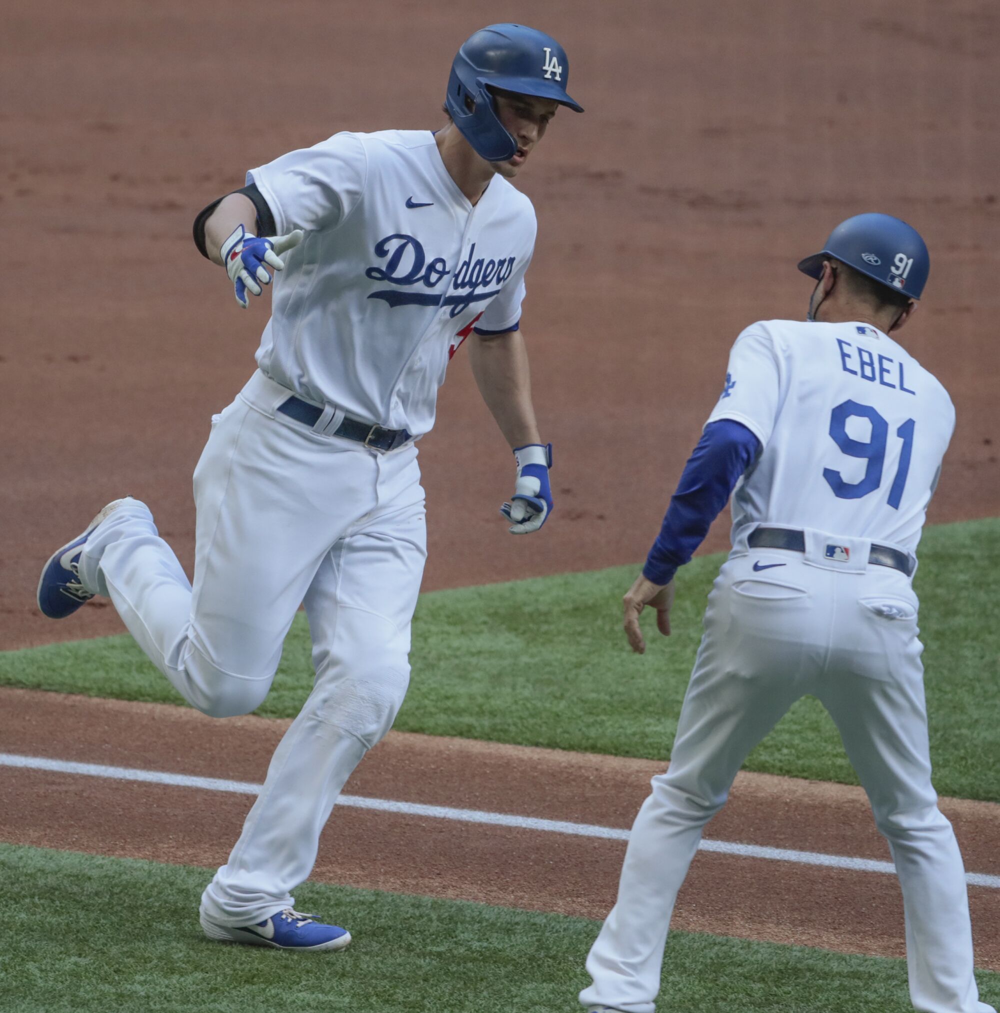 Dodgers shortstop Corey Seager is congratulated by third base coach Dino Ebel after hitting a solo home run.