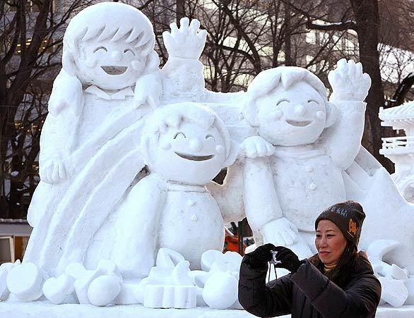 A woman takes photos today of ice sculptures before the opening of the 60th Sapporo Snow Festival at Odori Park in Sapporo, Japan. The Sapporo Snow Festival starts Thursday and goes to Feb. 11. More than 2 million tourists are expected to visit the festival.