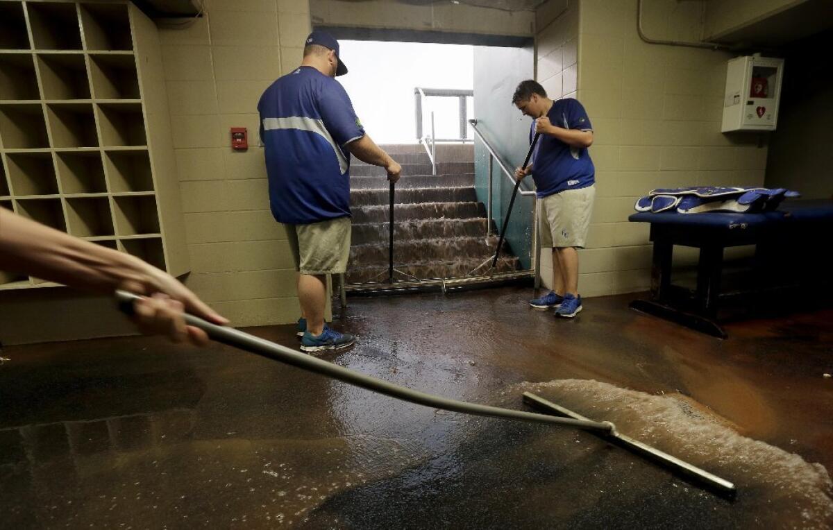 Grounds crew workers clear rainwater from the Royals dugout as a severe thunderstorm passed through the area. The Royals game against the Rays was postponed.