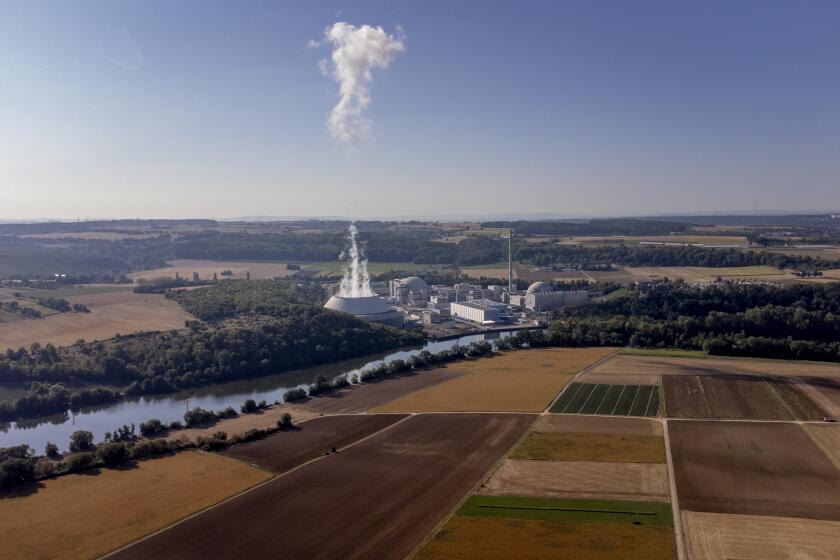FILE - Smoke rises from the nuclear power plant of Nerckarwestheim in Neckarwestheim, Germany, Aug. 22, 2022. German Chancellor Olaf Scholz ordered ministers Monday Oct. 17, 2022, to prepare to keep all of the country's three remaining nuclear plants running until mid-April, putting his foot down on an issue that had threatened to split his three-party government. (AP Photo/Michael Probst, File)