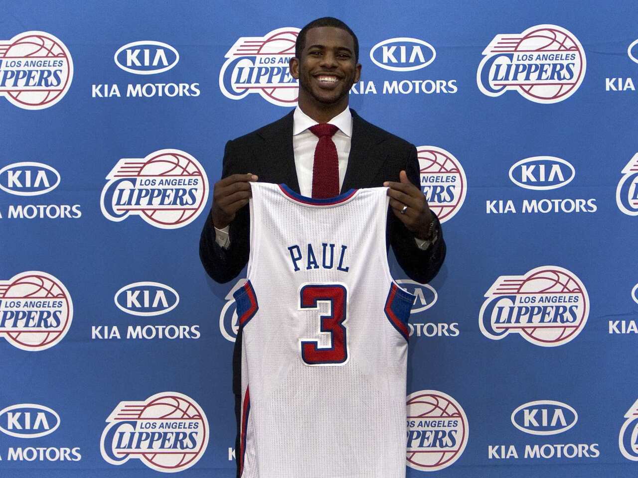 Clippers point guard Chris Paul poses with his new team jersey during a team news conference on Thursday.