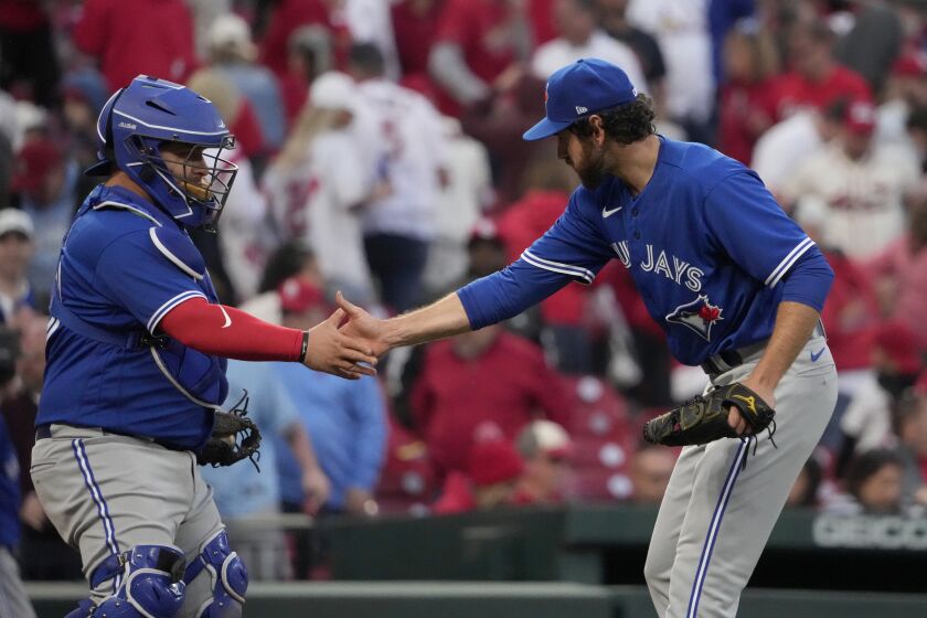 Toronto Blue Jays relief pitcher Jordan Romano, right, and catcher Alejandro Kirk celebrate a 10-9 victory over the St. Louis Cardinals in an opening day baseball game Thursday, March 30, 2023, in St. Louis. (AP Photo/Jeff Roberson)