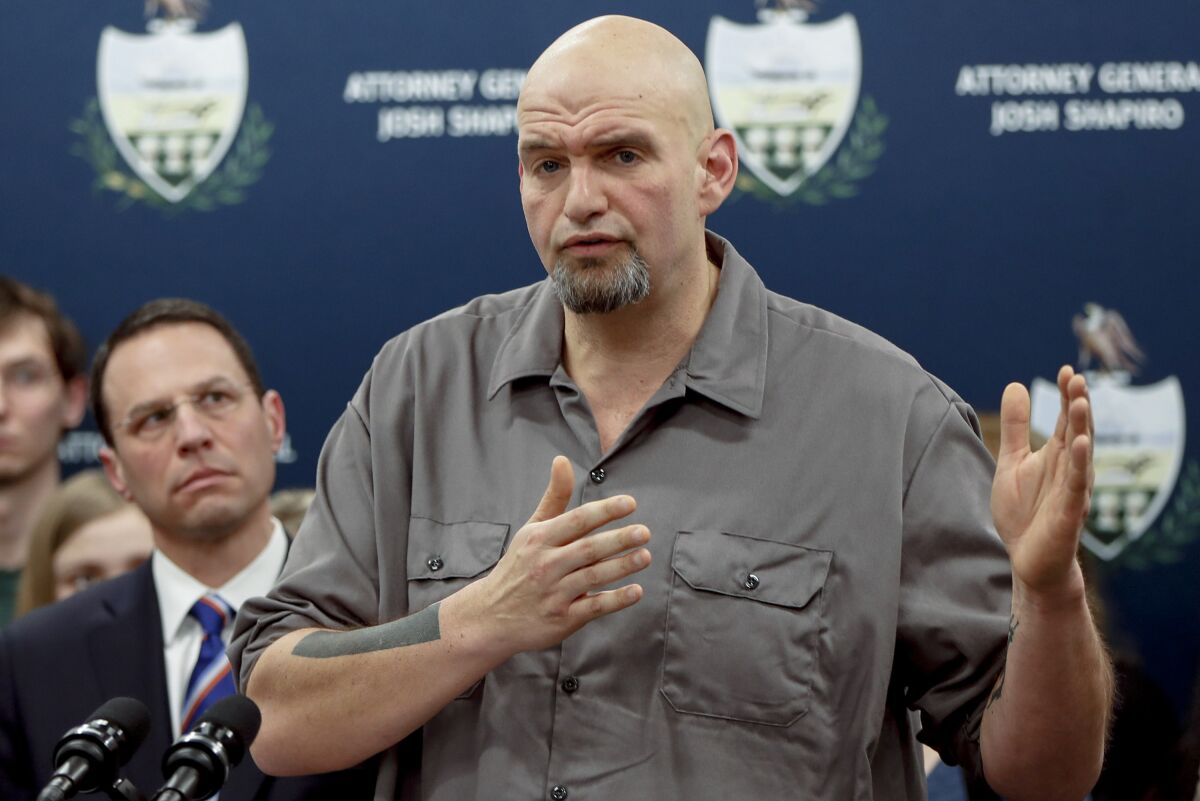 FILE - In this Feb. 7, 2019, file photo, Pennsylvania Lt. Gov. John Fetterman, right, speaks during a news conference in Pittsburgh. Democrats see one of their best chances to pick up a Senate seat in a Senate during next year’s midterms in Pennsylvania.(AP Photo/Keith Srakocic, File)