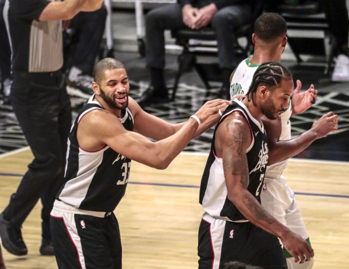 The Clippers' Nicolas Batum, left, gives Kawhi Leonard encouragement after a defensive stand.