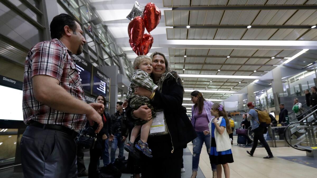 Nadia Hanan Madalo, who along with her family fled the violence in Iraq, hugs her nephew upon arriving at the San Diego airport in March.