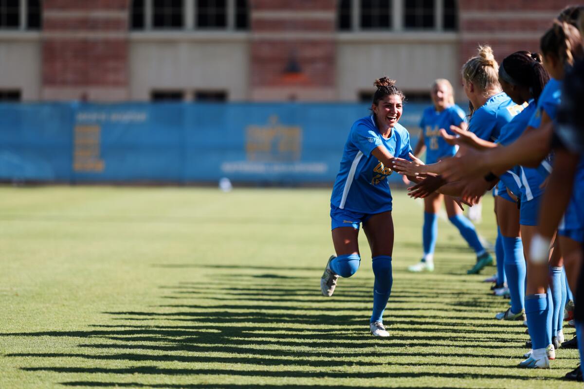 UCLA women's soccer's Madelyn Desiano high-fives teammates during a match.