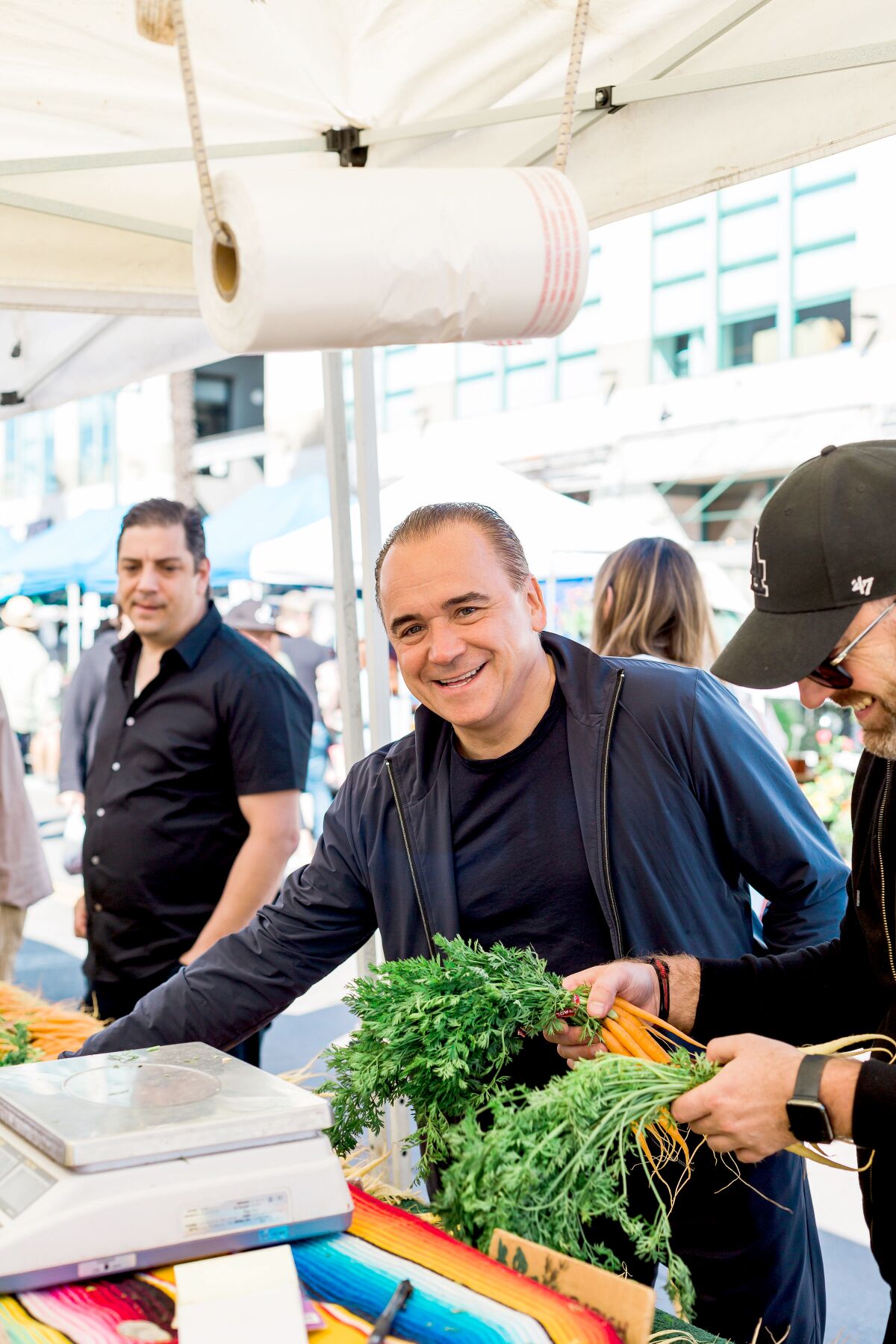 Jean-Georges Vongerichten, center, shops at the Santa Monica farmers market with members of his team, Daniel Del Vecchio, left, and Steve Benjamin.
