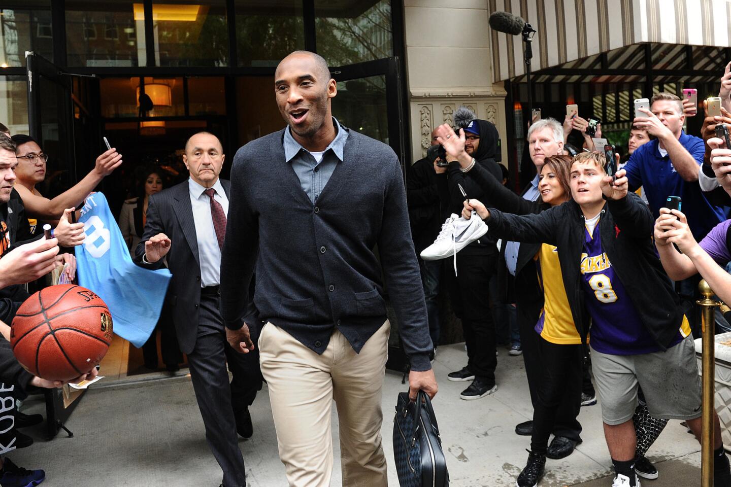 Kobe Bryant in street clothes talks to Chris Paul before the 2014