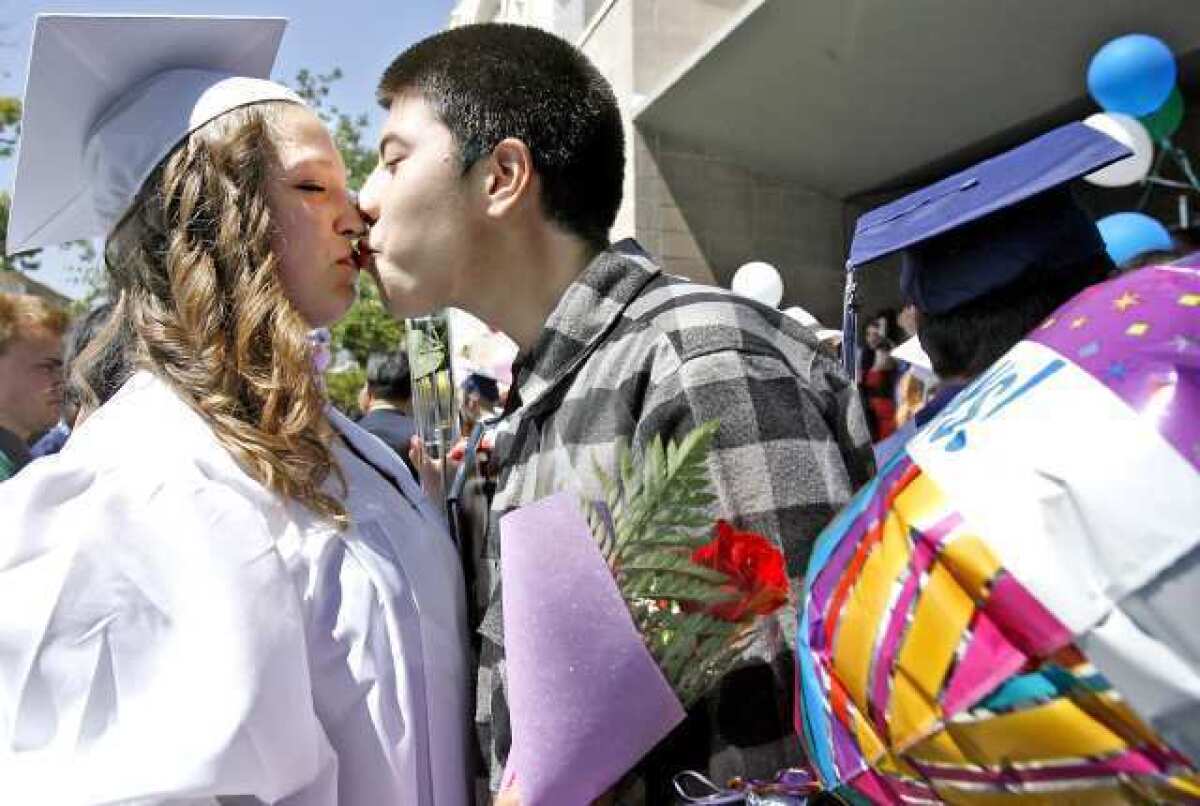 Krystal Griffin gets a kiss from her boyfriend, Oscar Hernandez, after the Re-connectEd Glendale graduation at the First United Methodist Church Carlson Fellowship Hall.