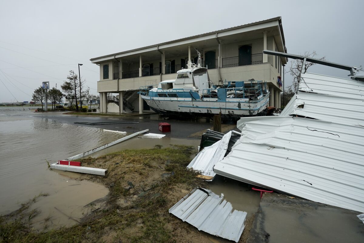 Flooding surrounds a damaged building and boat Friday in Cameron, La.