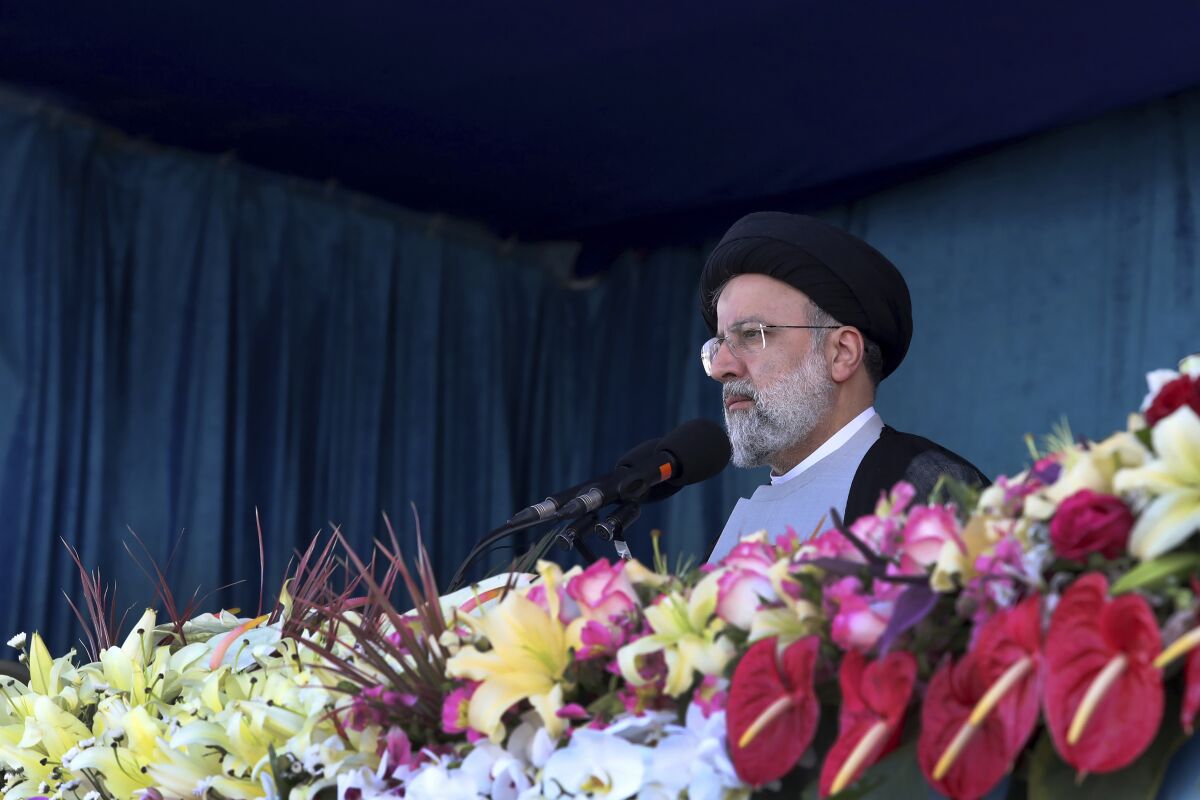 In this photo released by the official website of the office of the Iranian Presidency, President Ebrahim Raisi reviews the army troops parade commemorating National Army Day in front of the mausoleum of the late revolutionary founder Ayatollah Khomeini Monday, April 18, 2022, outside Tehran, Iran. Raisi warned that Israel will be targeted by his country's armed forces if it makes "the tiniest move" against Iran. (Iranian Presidency Office via AP)