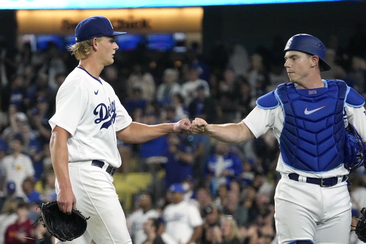 Dodgers pitcher Emmet Sheehan, left, and catcher Will Smith bump fists against the San Francisco Giants on June 16, 2023.