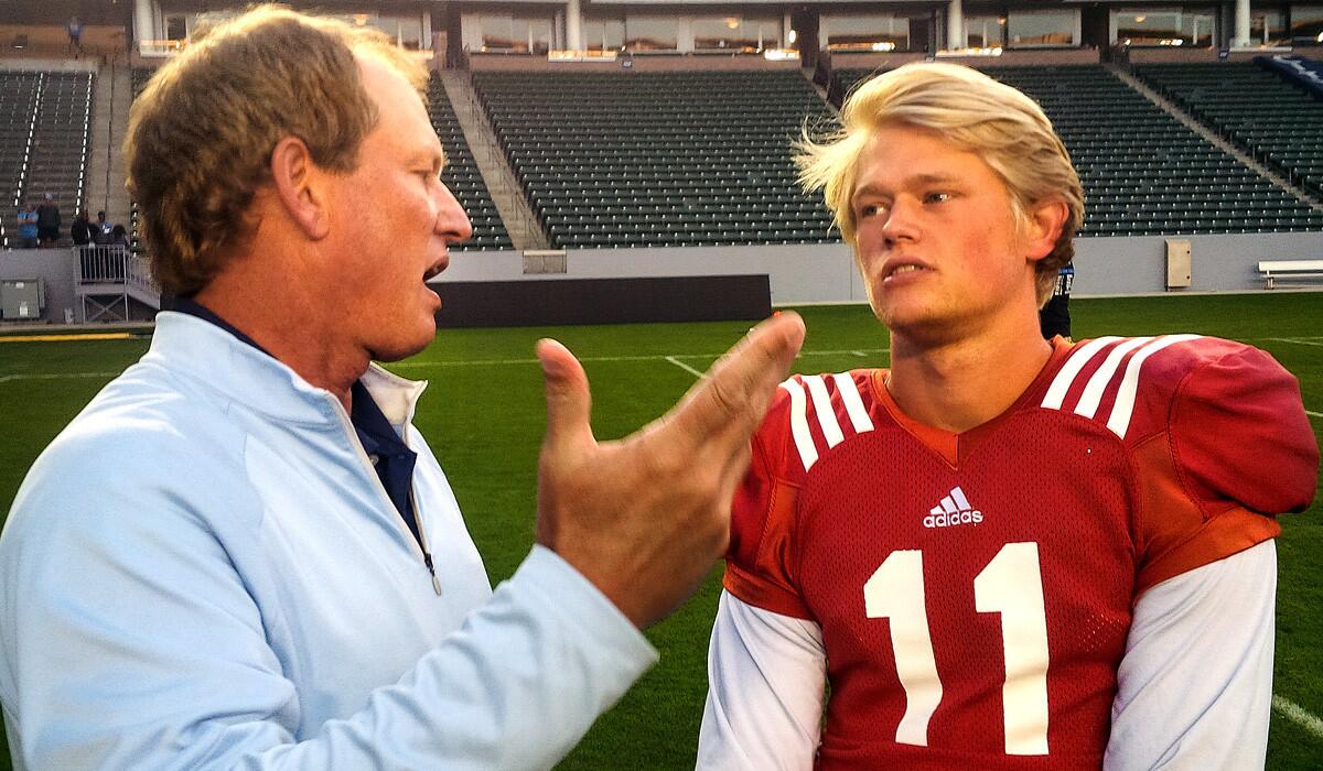 Former UCLA head coach Rick Neuheisel chats with his son Jerry after the Bruins' spring game in April at the StubHub Center.