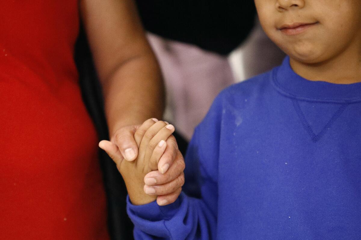 A mother holding a child's hand 