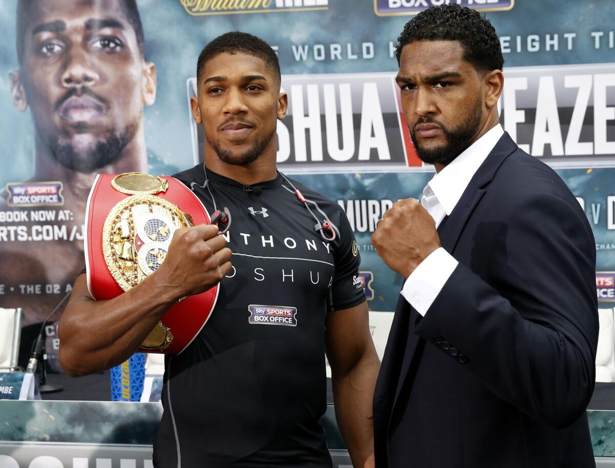 Anthony Joshua, left, and Upland's Dominic Breazeale flex during a news conference Thursday in London.