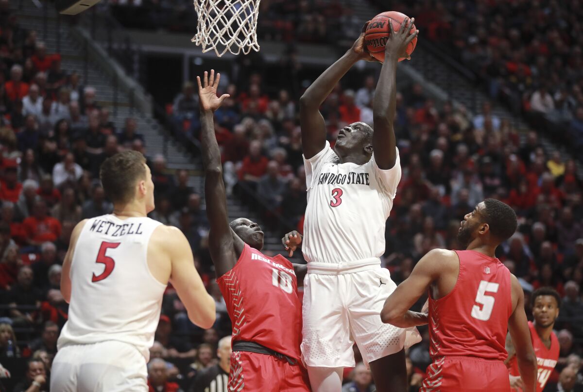 SDSU forward Aguek Arop (3) shoots over New Mexico's Makuach Maluach in a Feb. 11 game against New Mexico at Viejas Arena.