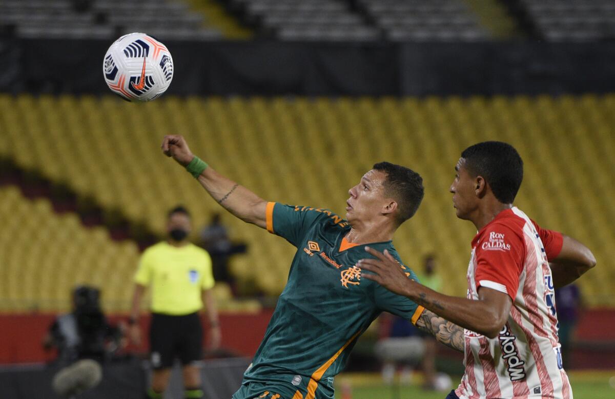 Lucas Calegari, of Brazil's Fluminense, and Gabriel Fuentes, of Colombia's Junior, battle for the ball 