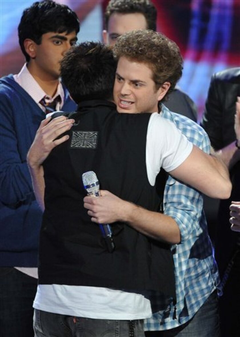 In this image released by Fox, contestant Scott MacIntyre, right, is embraced by other contestants after he was eliminated from the singing competition series, "American Idol," in Los Angeles on Wednesday, April 8, 2009. (AP Photo/Fox, Frank Micelotta)