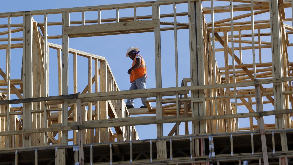 Workers build an apartment and retail complex in Nashville. U.S. economic growth in the first quarter was revised down to 2%, a sharp deceleration and the poorest showing in a year.
