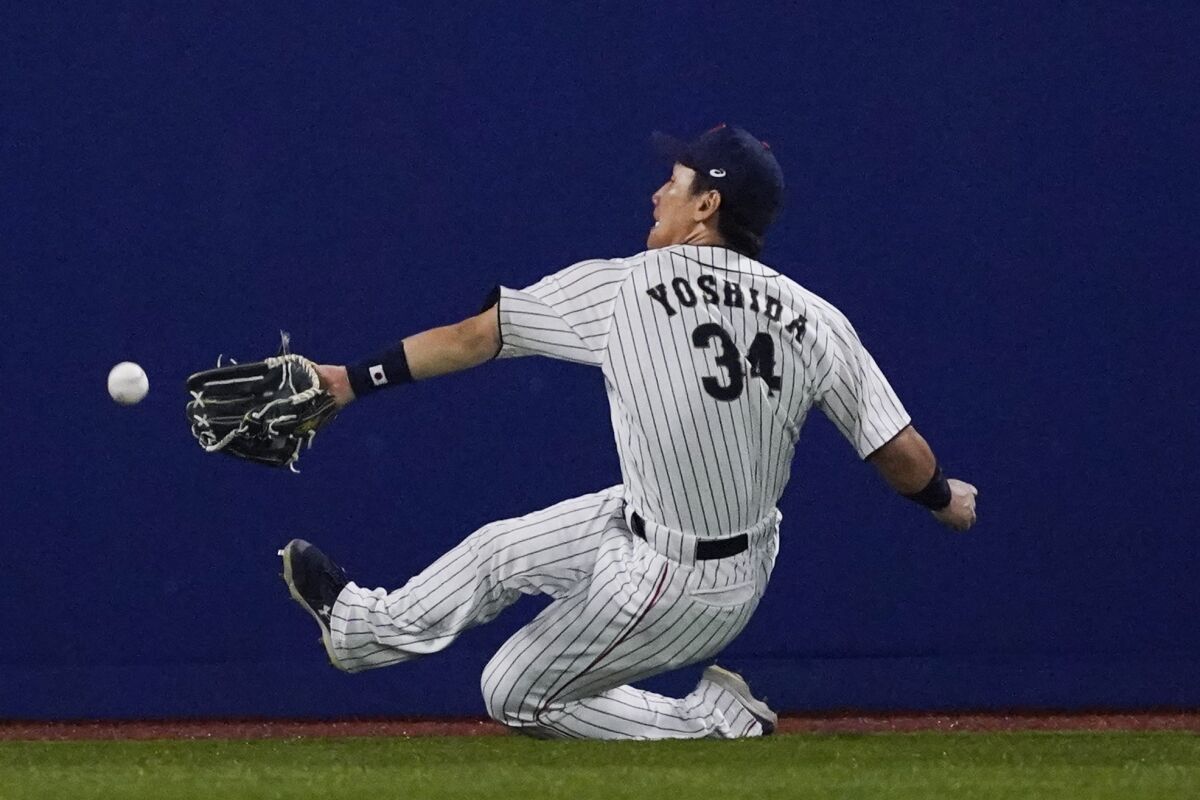 FILE - Japan's Masataka Yoshida cannot reach a ball hit by United States' Triston Casas during the seventh inning of a baseball game at the 2020 Summer Olympics, Aug. 2, 2021, in Yokohama, Japan. Yoshida will be able to negotiate with Major League Baseball teams starting Wednesday, Dec. 6, 2022, under the posting system with the Japanese big leagues. (AP Photo/Sue Ogrocki, File)