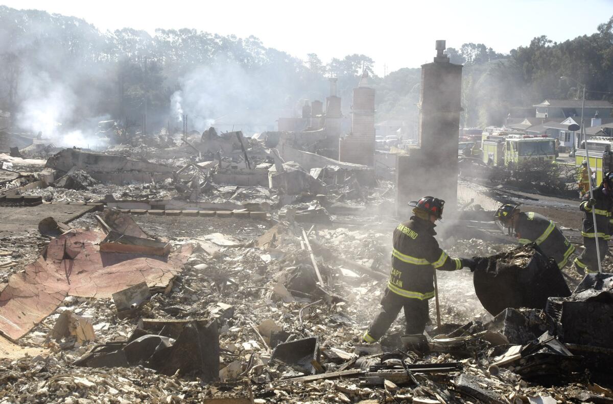 In this file photo, firefighters check for hot spots in the rubble of homes along Claremont Drive in San Bruno, Calif., where a large underground natural gas pipeline exploded in 2010.