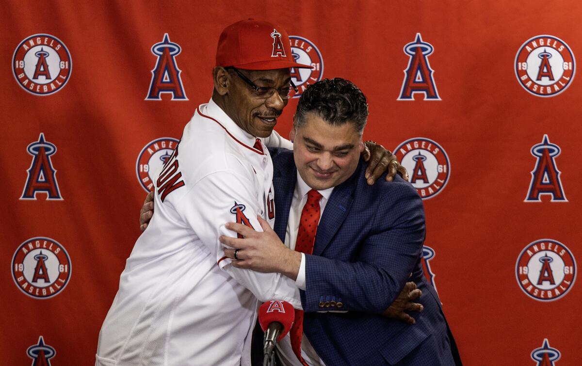 Angels manager Ron Washington, left, and general manager Perry Minisian hug during a news conference on Nov. 15, 2023.