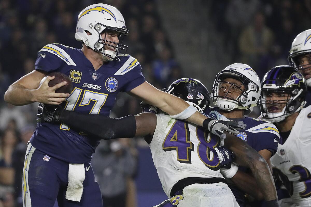 Chargers quarterback Philip Rivers tries to avoid Ravens linebacker Patrick Onwuasor during a third quarter drive at StubHub Center on Saturday.