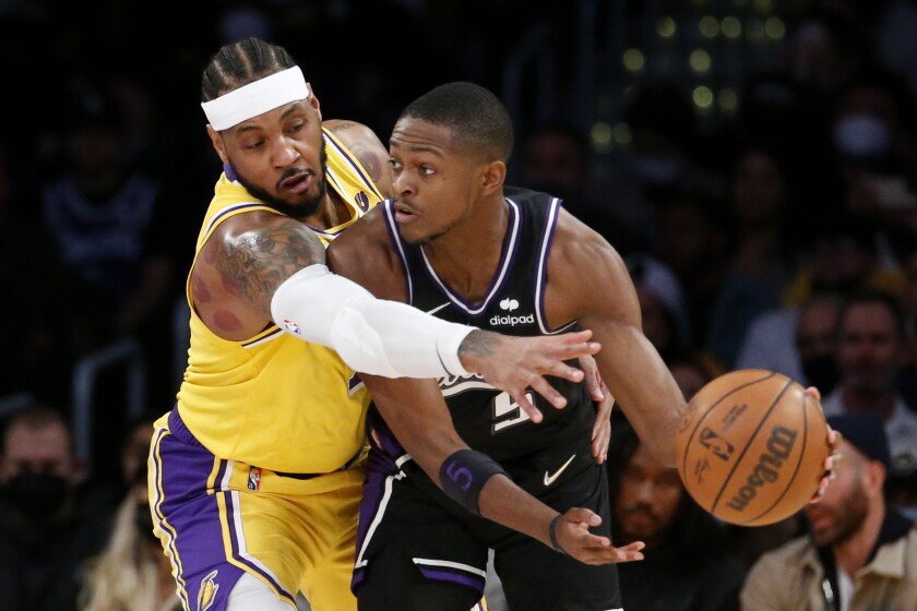 Lakers forward Carmelo Anthony plays tight defense against Kings guard De'Aaron Fox.