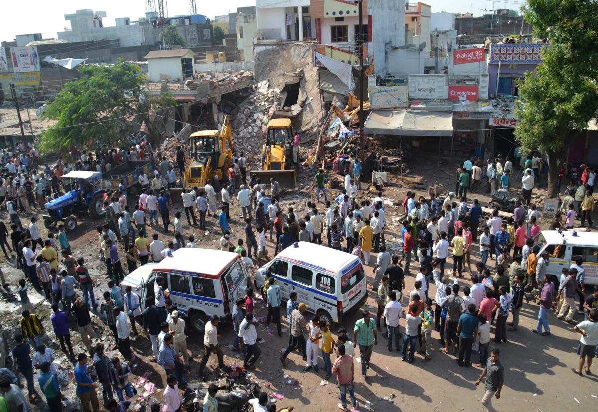 Trabajadores con maquinaria pesada retiran escombros en el site donde hubo dos explosiones en Petlawad, India. (Foto AP/Manoj Jani)