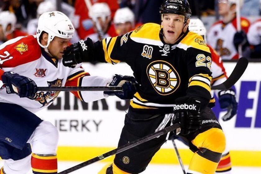 Bruins left wing Shawn Thornton looks to pass under pressure from Panthers right wing Krys Barch during a game last month in Boston.